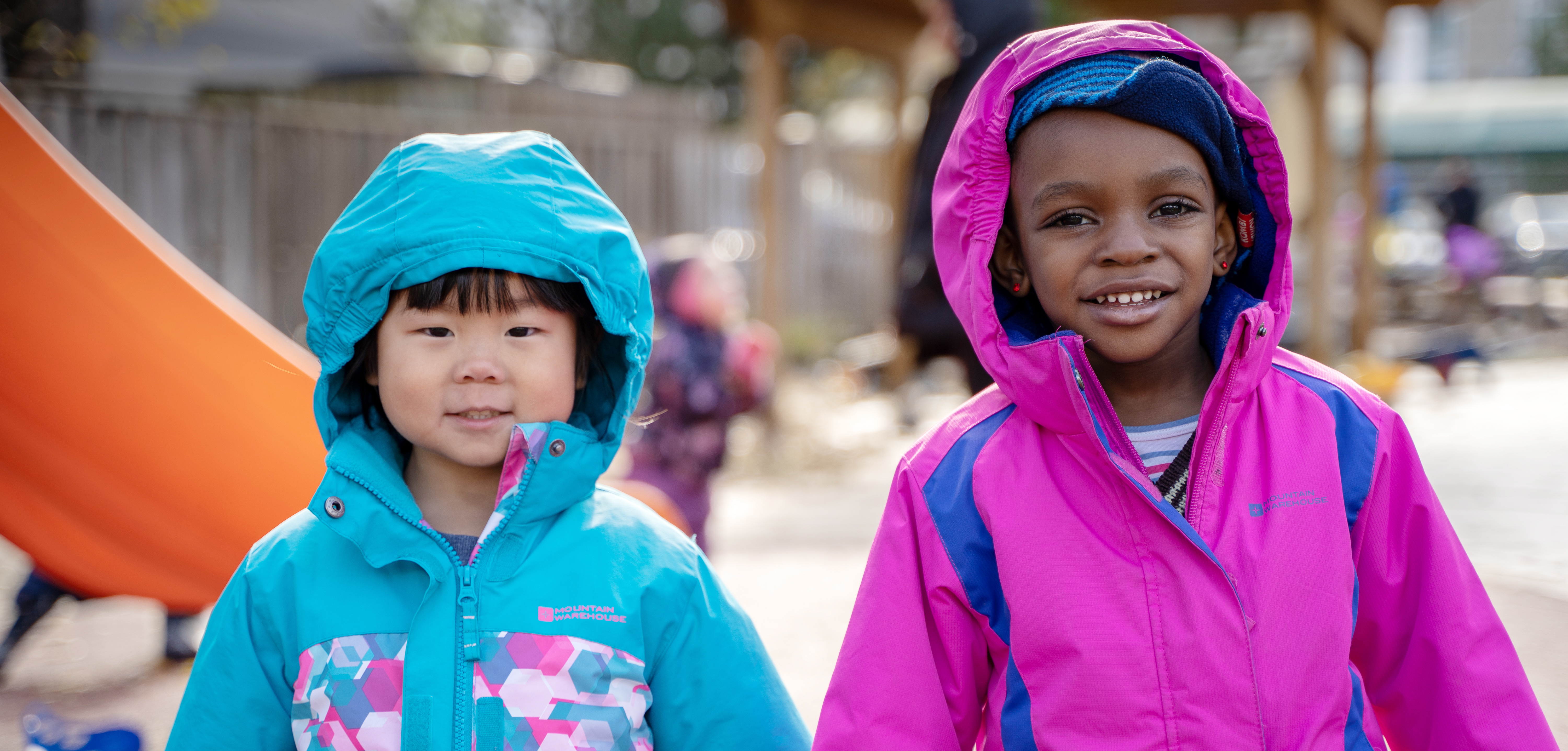 Two smiling girls playing outside