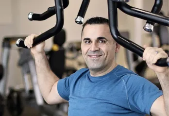 John performs upper body exercises at his local Y.
