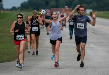 Runners celebrate with hands in the air as they participate in Jordan's Run The Runway.