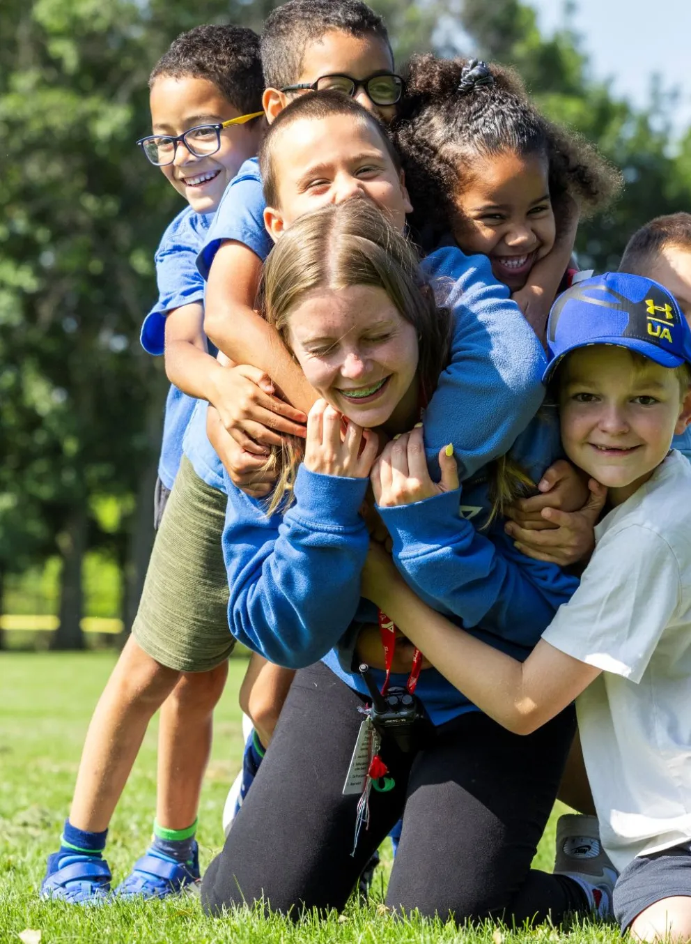 Kids hugging a counsellor at camp