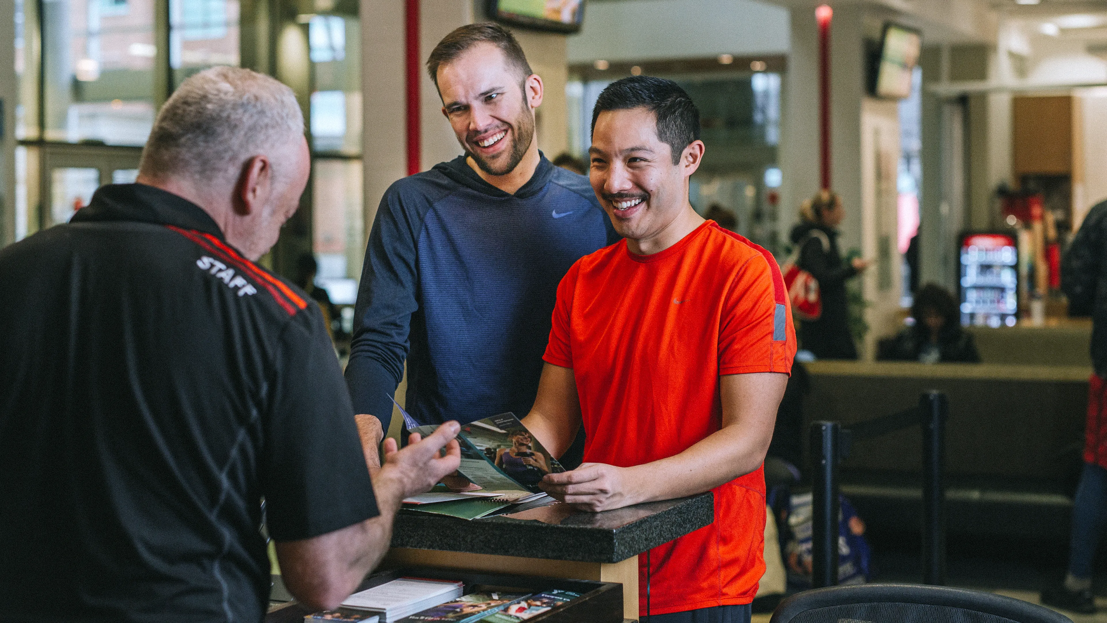 Staff helping YMCA members at the front desk