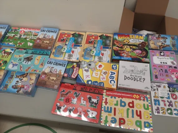 A variety of kids activities are laid out across a table, ready to be packed into camp kits.