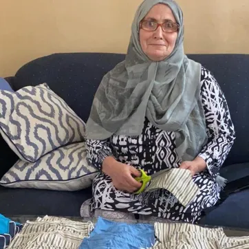 Afiyat, a skilled tailor, sews masks for the community.