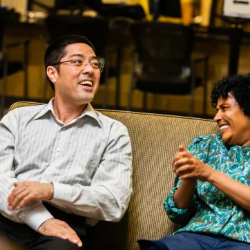 A man and woman sit together, laughing and talking.