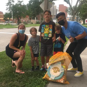 A family with three boys smile and pose with their Kids Club Kit.