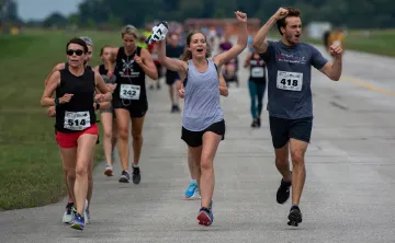 Runners celebrate with hands in the air as they participate in Jordan's Run The Runway.